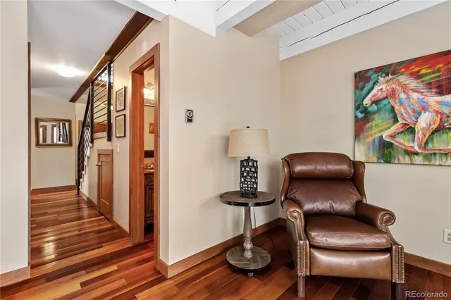 a view of a hallway with furniture and wooden floor
