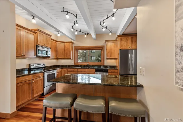 a kitchen with stainless steel appliances granite countertop a stove a sink dishwasher and a refrigerator