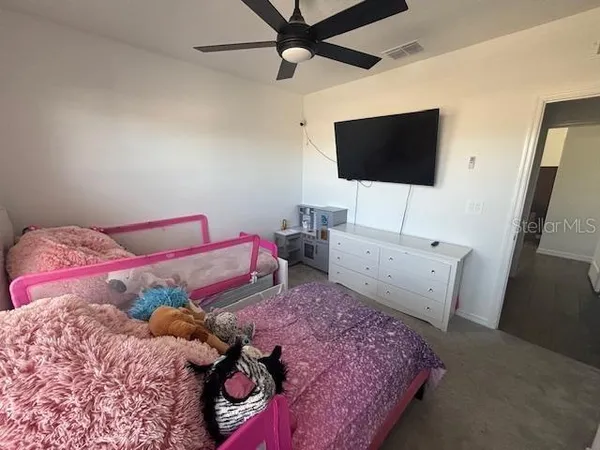 a bedroom with a bed table and a chandelier