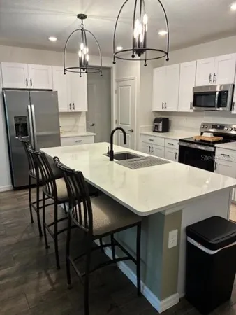 a kitchen with a table chairs microwave and cabinets