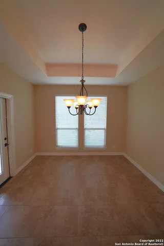 a view of a room with a chandelier fan and windows