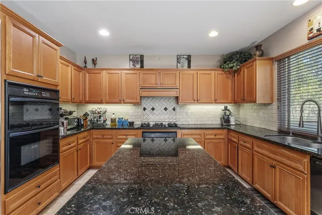 a kitchen with stainless steel appliances granite countertop a stove sink microwave and cabinets