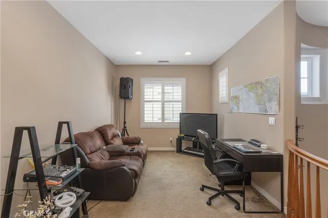 a living room with furniture a flat screen tv and a window