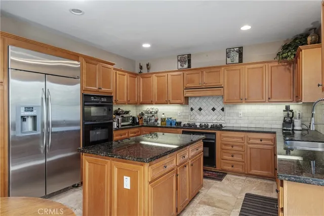a kitchen with granite countertop a sink stainless steel appliances and cabinets