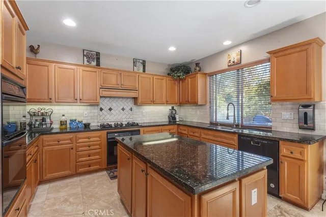 a kitchen with stainless steel appliances granite countertop a sink stove and cabinets