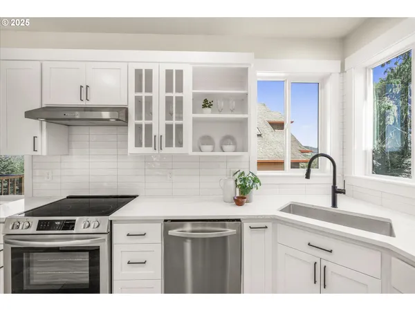 a kitchen with stainless steel appliances a sink stove and cabinets