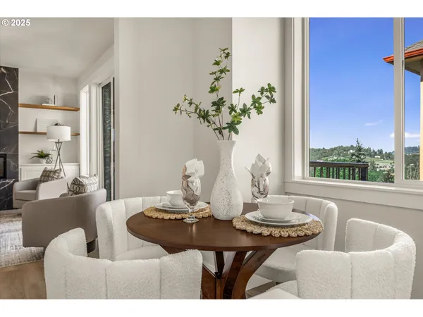 a view of a dining room with furniture a potted plant and a large mirror