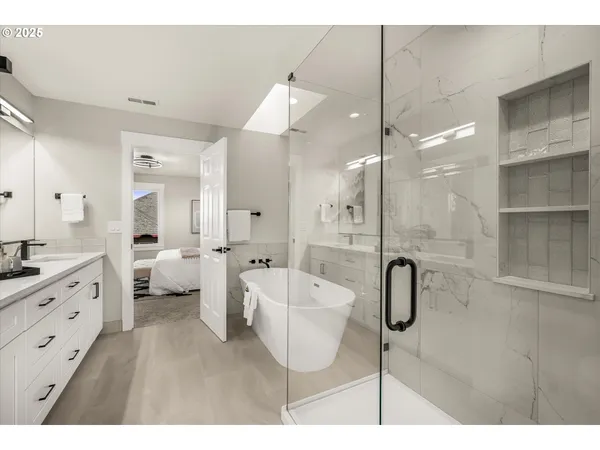 a spacious bathroom with a double vanity sink a mirror and a shower