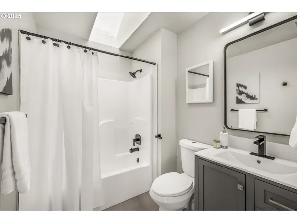 a bathroom with a sink toilet a mirror and shower