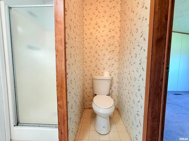 a bathroom with a toilet and a shower