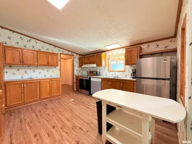 a kitchen with stainless steel appliances a refrigerator and wooden cabinets