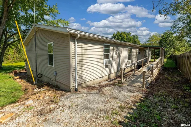 a view of a house with a yard and wooden fence