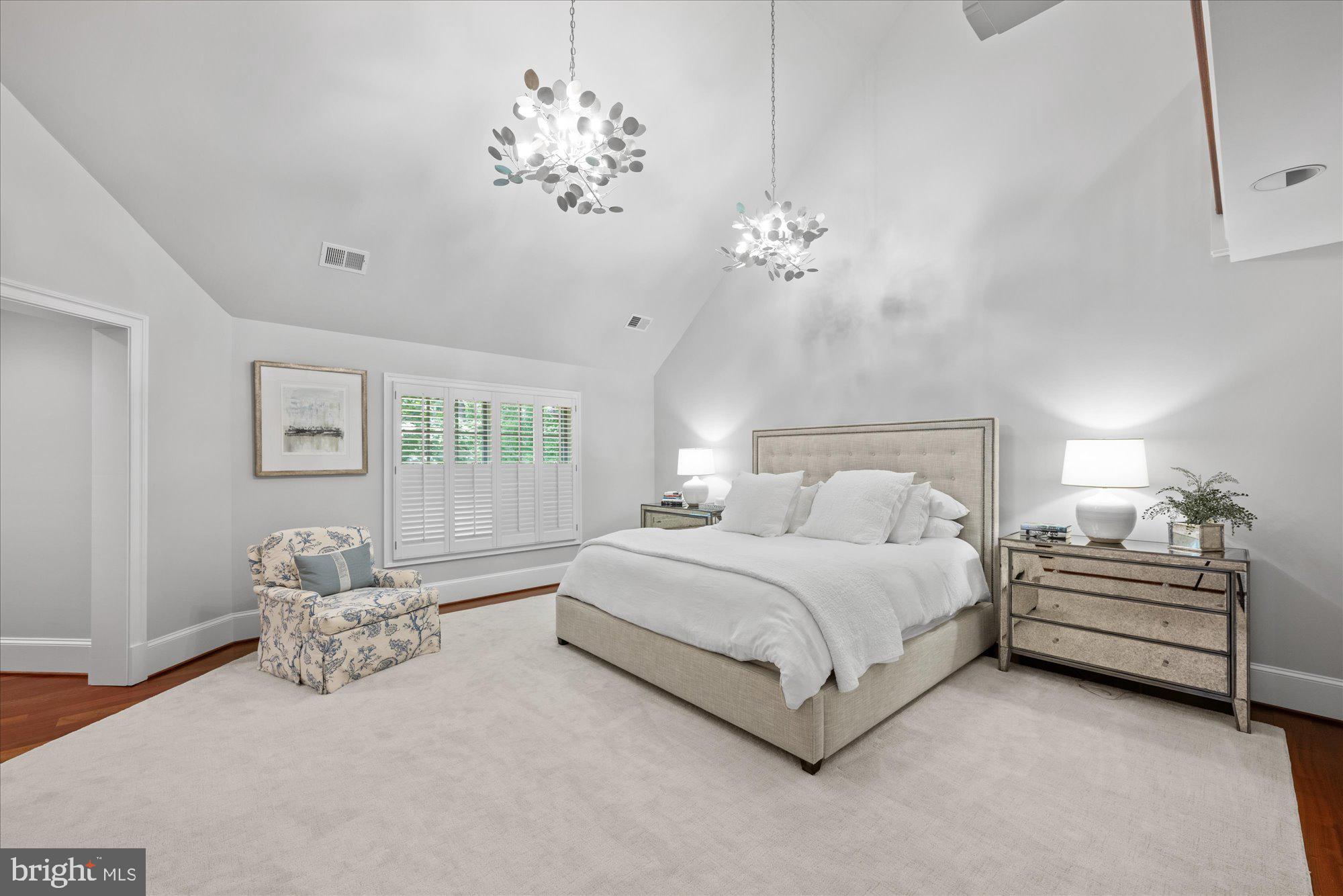 11512 Morning Ride Drive Potomac, MD 20854 - Photo 25 of 51 a spacious bedroom with a bed and a chandelier