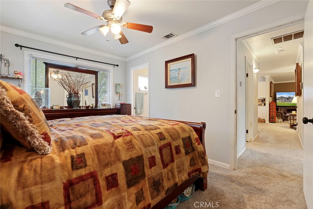 424 Morada Lane Stockton, CA 95210 - Photo 18 of 51 a bedroom with a large bed and a chandelier