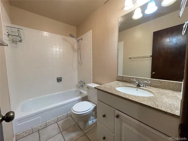 a bathroom with a granite countertop sink a mirror and a bathtub