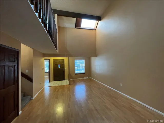a view of an empty room with wooden floor