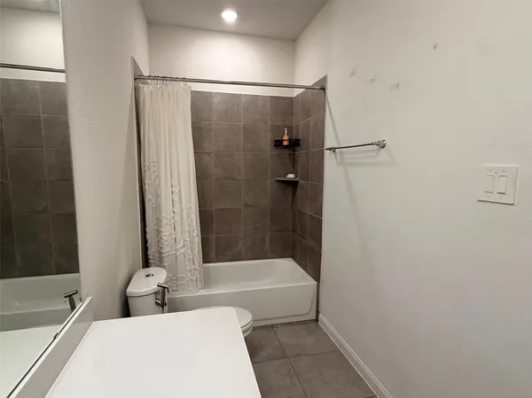 a bathroom with a tub shower sink and vanity