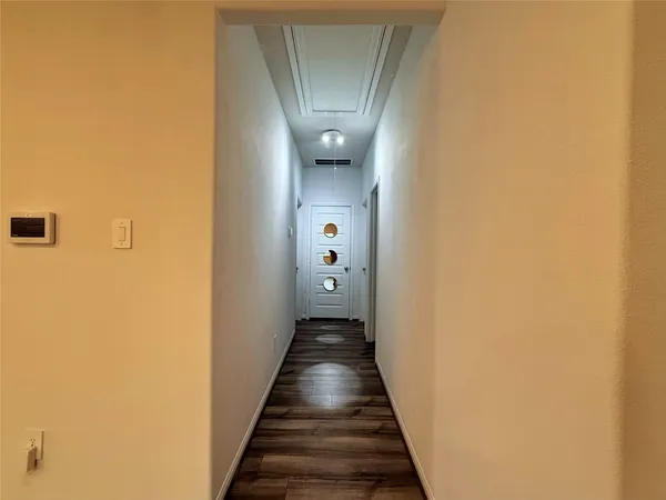 a view of a hallway with wooden floor