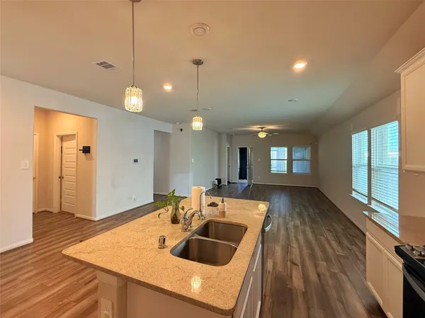 a view of a kitchen island a chandelier and wooden floor