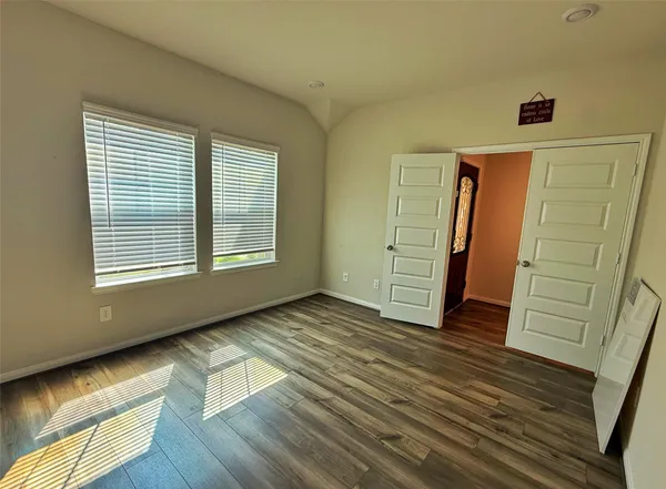 a view of an empty room with closet and a window