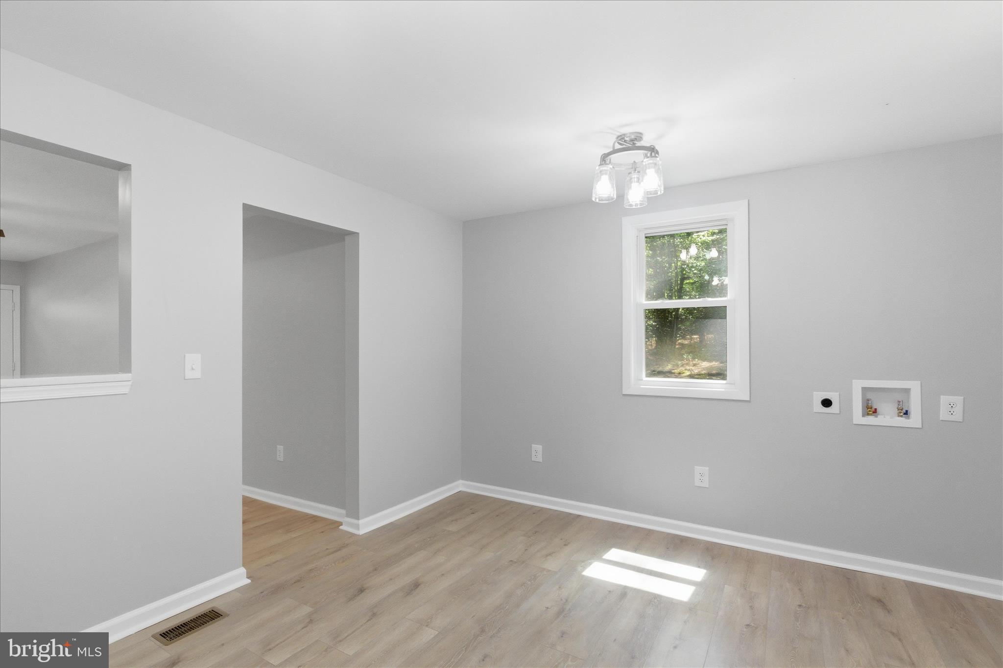 6815 Marshall Road St. Leonard, MD 20685 - Photo 15 of 43 an empty room with wooden floor cabinet and windows