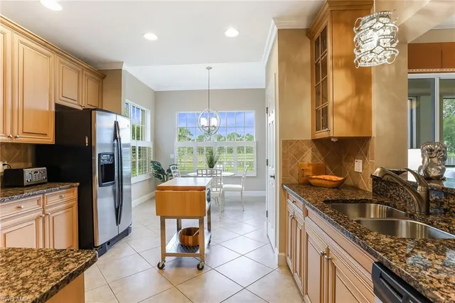 a kitchen with granite countertop a sink stove and refrigerator