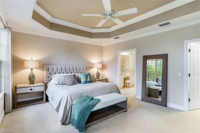 a bedroom with a large bed and a chandelier