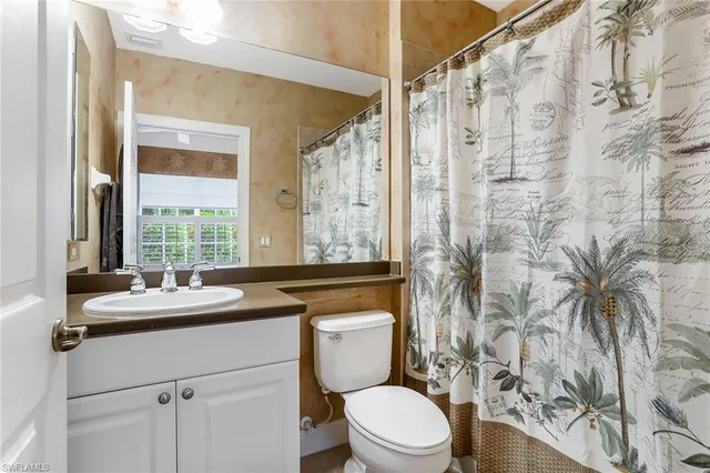 a bathroom with a sink a toilet a mirror and a shower