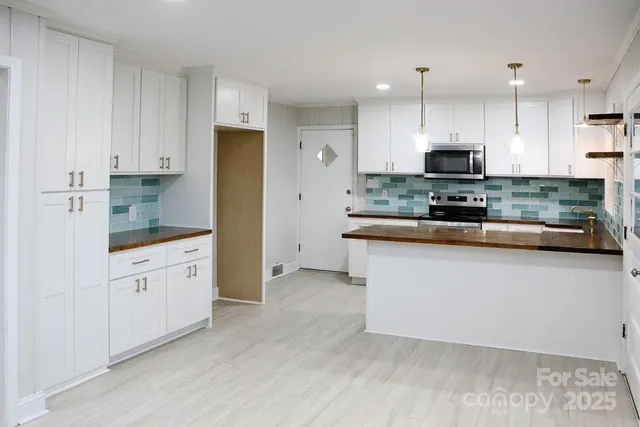 a kitchen with stainless steel appliances granite countertop a stove a sink and a refrigerator