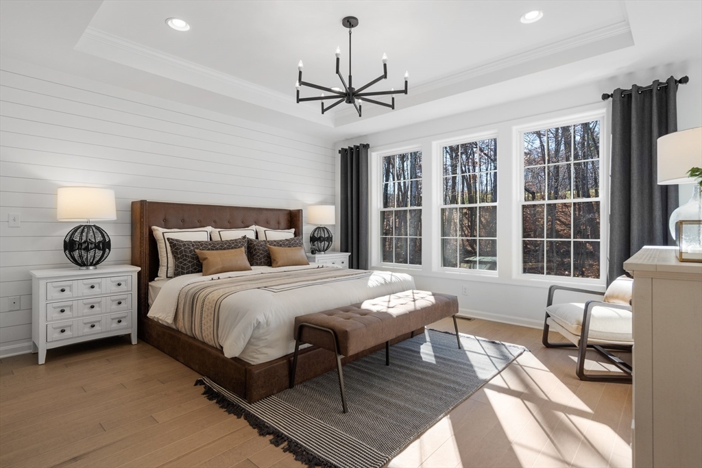 25 Sandtrap Circle, Unit 8 Walpole, MA 02081 - Photo 11 of 15 a bedroom with a bed and wooden floor