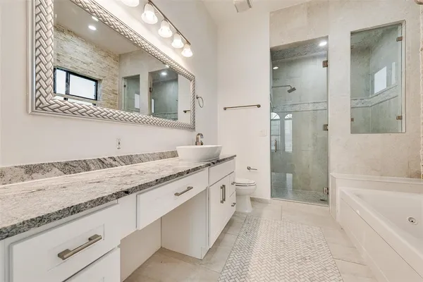 a bathroom with a granite countertop sink mirror and bathtub