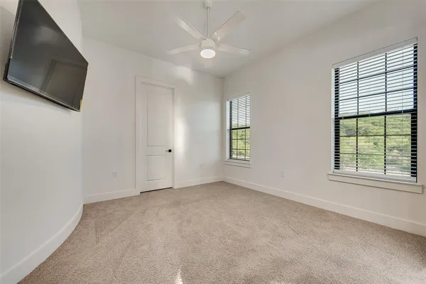 an empty room with windows and fireplace