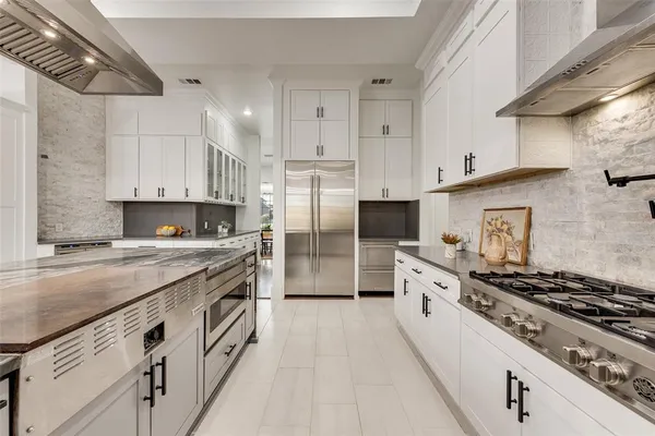 a large kitchen with stainless steel appliances granite countertop a stove a sink and a refrigerator