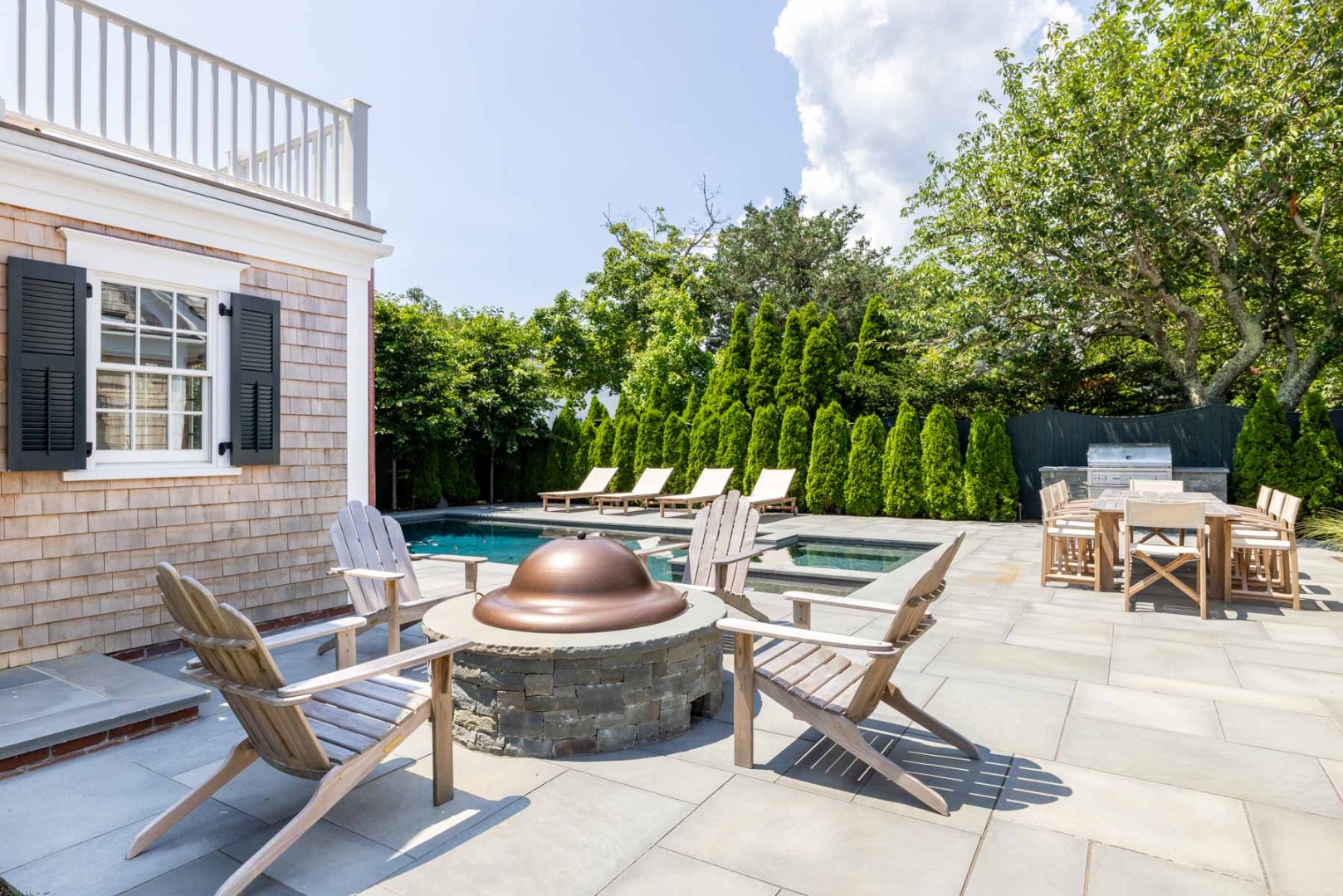 56 North Summer Street Edgartown, MA 02539 - Photo 77 of 77 a view of a patio with a dining table and chairs with a small yard and a fire pit