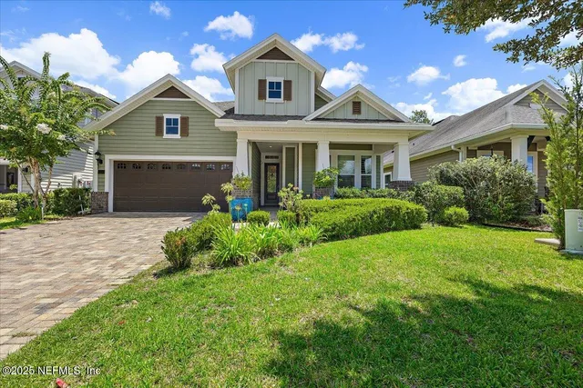 a front view of a house with a yard and potted plants