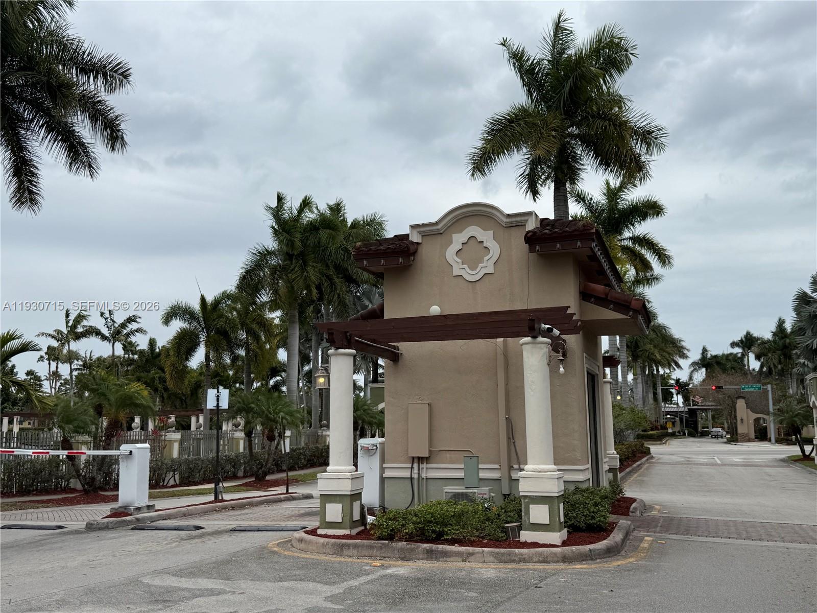 a view of a street with a building and palm trees