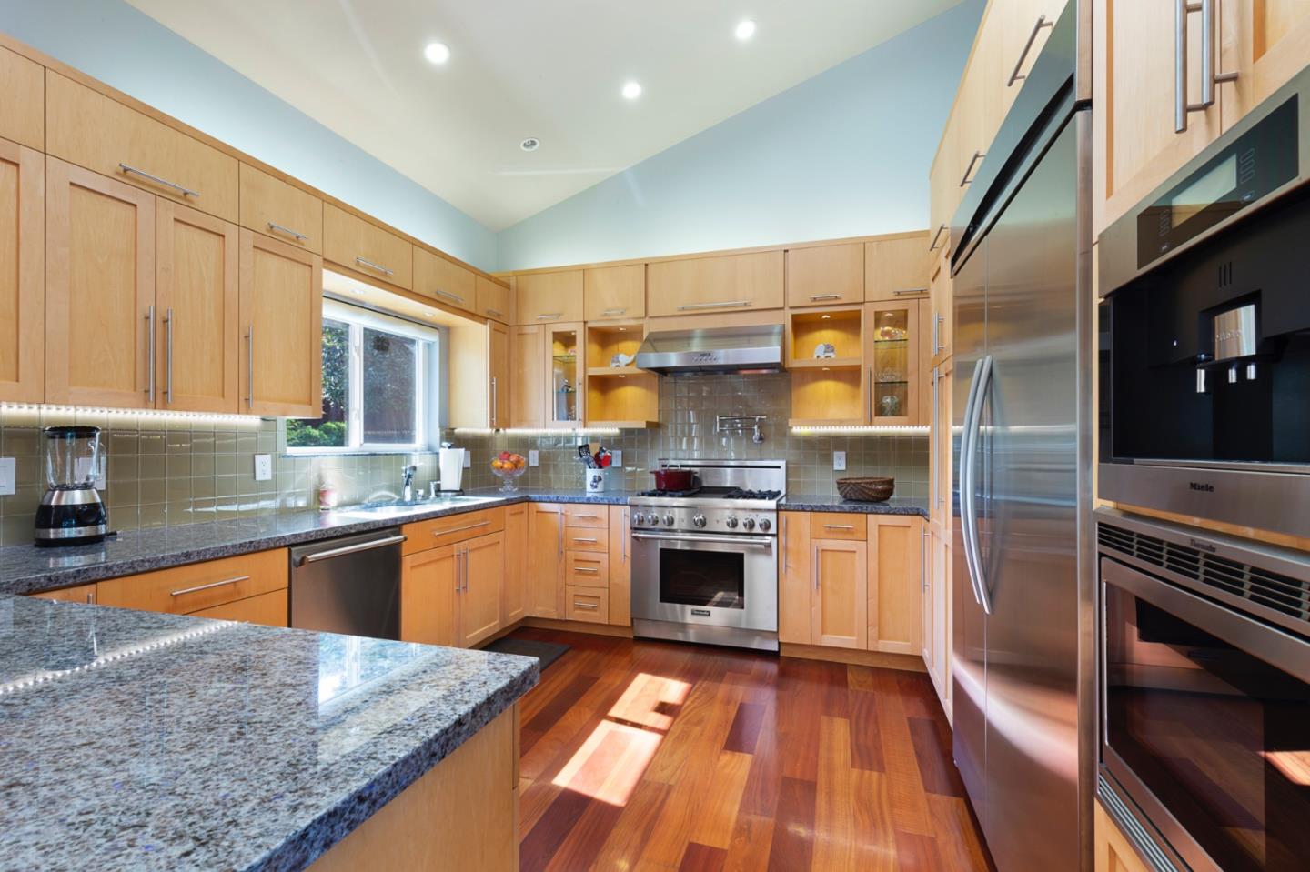 36 Tobin Clark Drive Hillsborough, CA 94010 - Photo 26 of 50 a kitchen with stainless steel appliances granite countertop a stove top oven a sink dishwasher a dining table and chairs with wooden floor