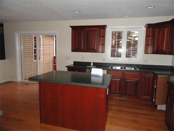 9 Vinton Road Sturbridge, MA 01566 - Photo 5 of 12 a kitchen with stainless steel appliances granite countertop wooden cabinets a refrigerator a stove a sink and dishwasher with wooden floor