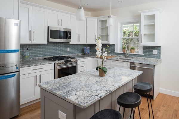 a kitchen with granite countertop kitchen island a table and a sink