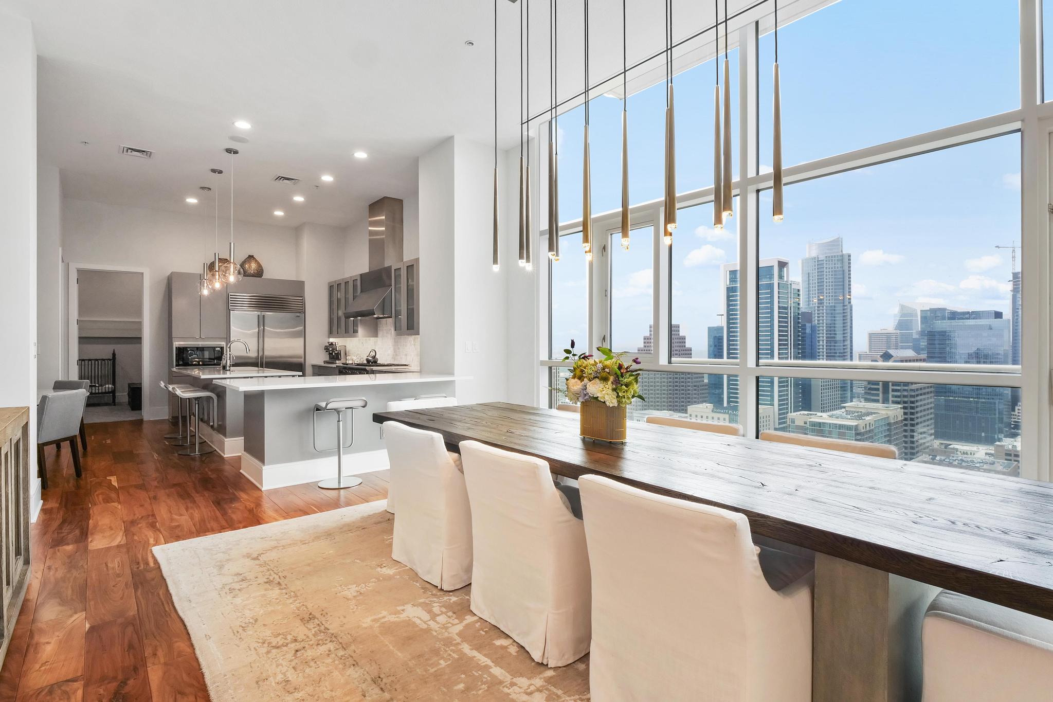 555 East 5th Street, Unit 3022 Austin, TX 78701 - Photo 3 of 40 Dining room with a city view, dark wood finished floors, recessed lighting, a high ceiling, and a wall of windows