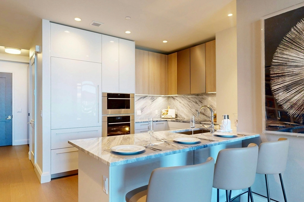 240 Devonshire Street, Unit 4210 Boston, MA 02110 - Photo 2 of 39 a kitchen with kitchen island stainless steel appliances a stove a sink and a refrigerator