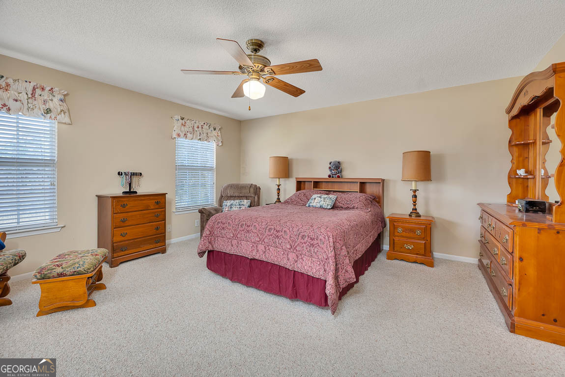 1056 Fiddler Trace Townsend, GA 31331 - Photo 19 of 36 a bedroom with a bed and a chandelier