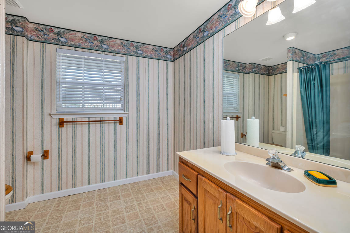 1056 Fiddler Trace Townsend, GA 31331 - Photo 24 of 36 a bathroom with a granite countertop sink and a mirror