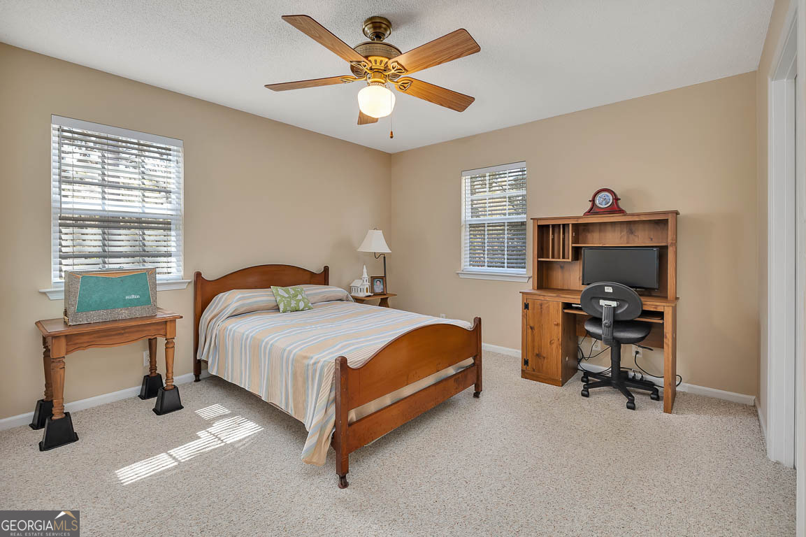 1056 Fiddler Trace Townsend, GA 31331 - Photo 29 of 36 a bedroom with a bed and a table with a bookshelf