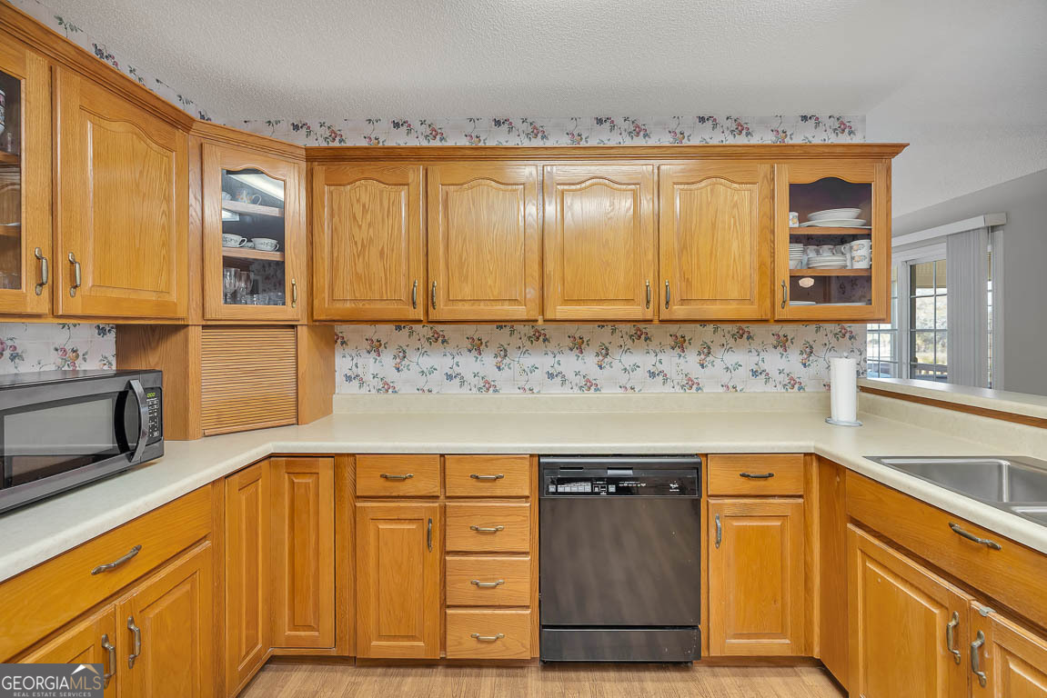 1056 Fiddler Trace Townsend, GA 31331 - Photo 4 of 36 a kitchen with stainless steel appliances granite countertop wooden cabinets a sink and dishwasher