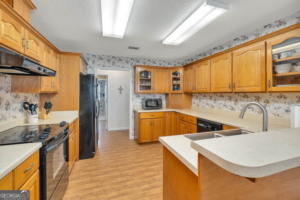 1056 Fiddler Trace Townsend, GA 31331 - Photo 5 of 36 a kitchen with stainless steel appliances granite countertop a sink a stove and a refrigerator