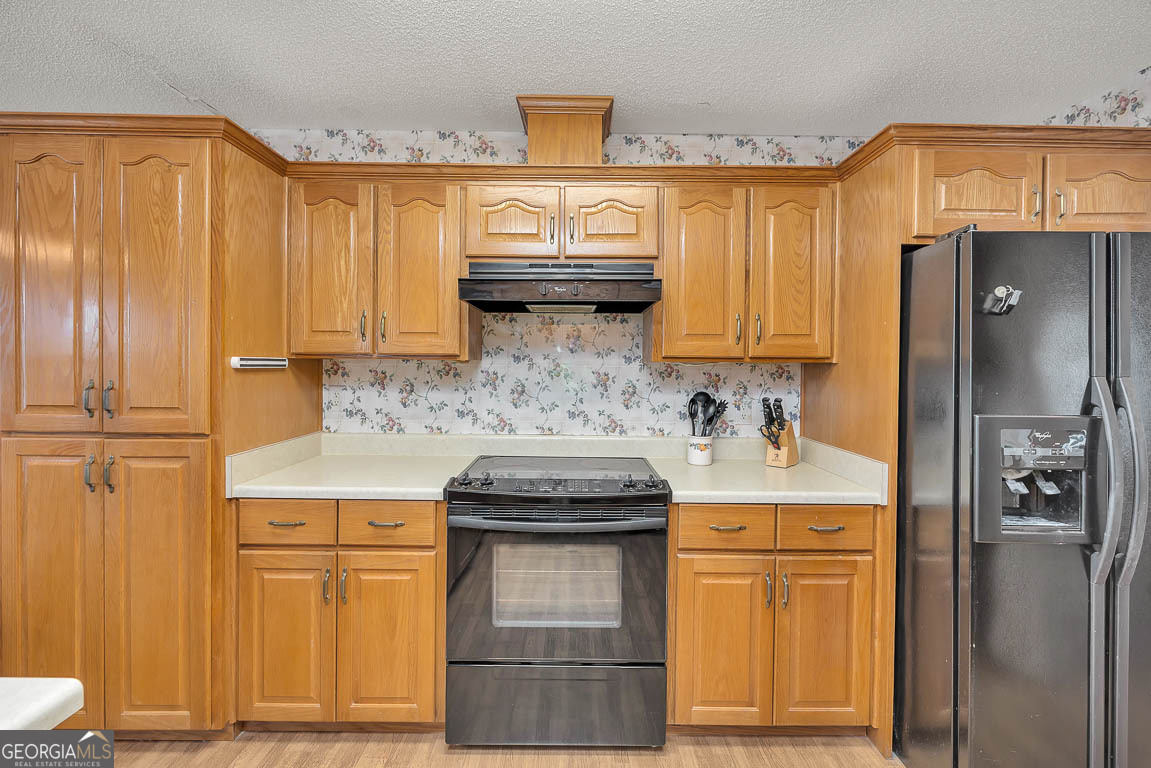1056 Fiddler Trace Townsend, GA 31331 - Photo 6 of 36 a kitchen with stainless steel appliances granite countertop cabinets and a refrigerator