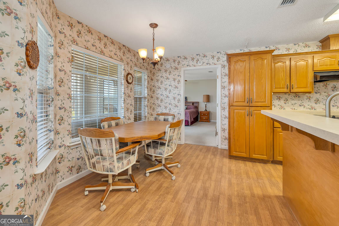 1056 Fiddler Trace Townsend, GA 31331 - Photo 7 of 36 a dining room with stainless steel appliances a dining table wooden floor and a chandelier
