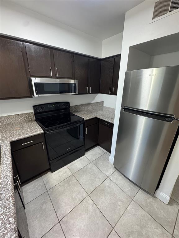 1197 Bentley Road, Unit 3 Leesburg, FL 34748 - Photo 5 of 14 a kitchen with a refrigerator sink and cabinets