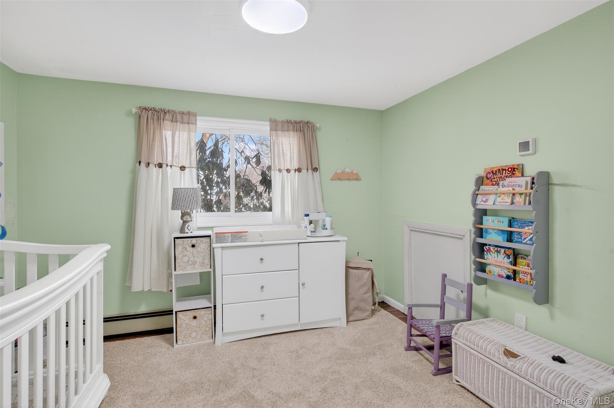 95 Sutton Park Road Poughkeepsie, NY 12603 - Photo 14 of 26 a bedroom with a baby bed a desk and chair